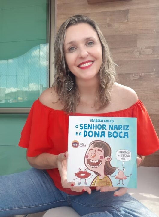 Isabela Gallo segurando o livro O Senhor Nariz e a Dona Boca